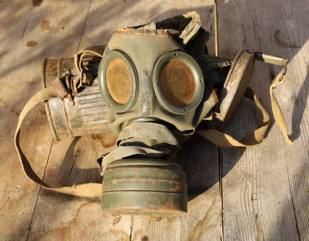 istock German Army old gas mask and its container on weathered wood plank. 2085506119