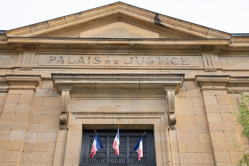 palais de justice text on ancient wall facade building means in french courthouse justice court with france flag