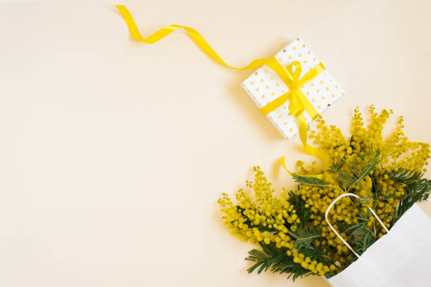 istock Beautiful flowers with package and present composition. Branches flowers mimosa on white background. Valentines Day, Easter, Birthday, Mother's day. Flat flat, top view, copy space. Spring Sale 2085552448