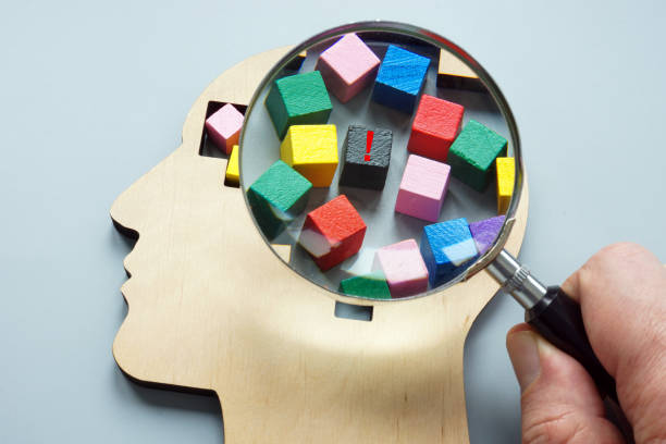 istock Psychoanalysis and negative emotions. A hand with a magnifying glass examines wooden head. 2085557668