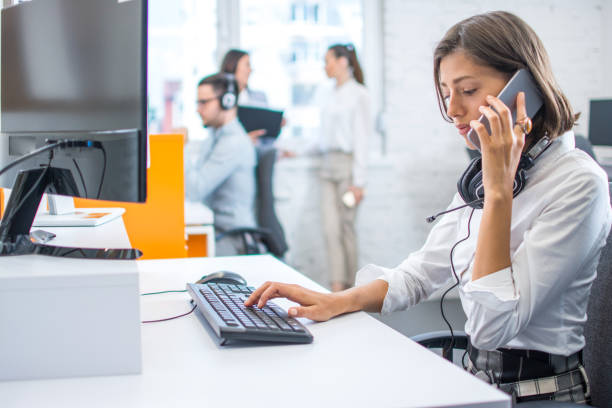 istock Concerned woman talking on mobile phone, getting bad news and feeling depressed while working on computer at office. 2085565579