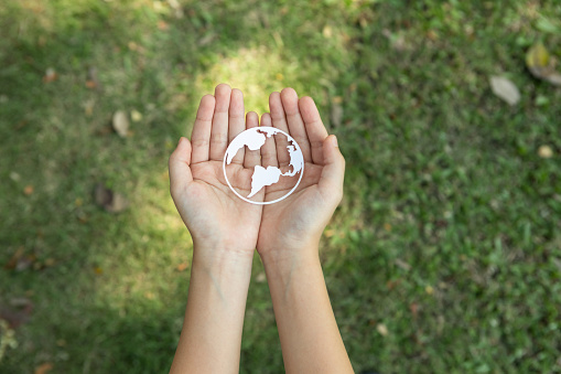 Top view hand holding Earth planet icon symbolize eco-friendly commitment to environmental protection and zero carbon emission. Earth World Day concept to promote eco awareness. Gyre