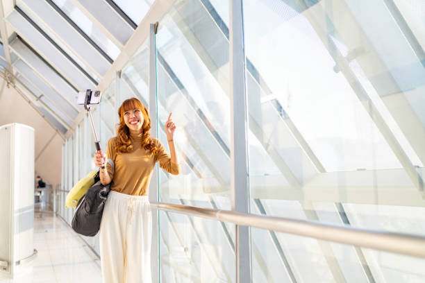 istock Asian woman using smartphone in airport terminal. 2085571847