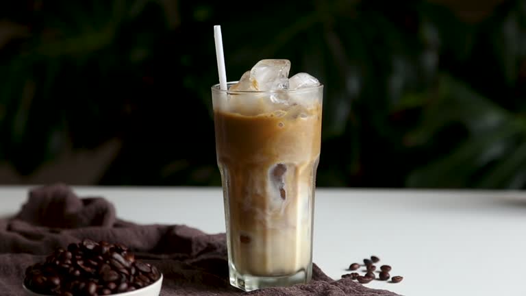 Hand people pouring milk make iced latte coffee Summer drink.