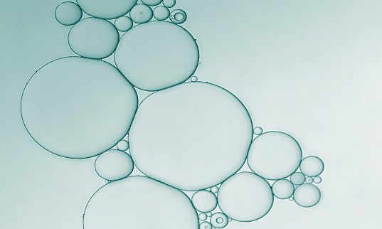 Abstract pale green oil and water droplets to create bubbles pattern background.