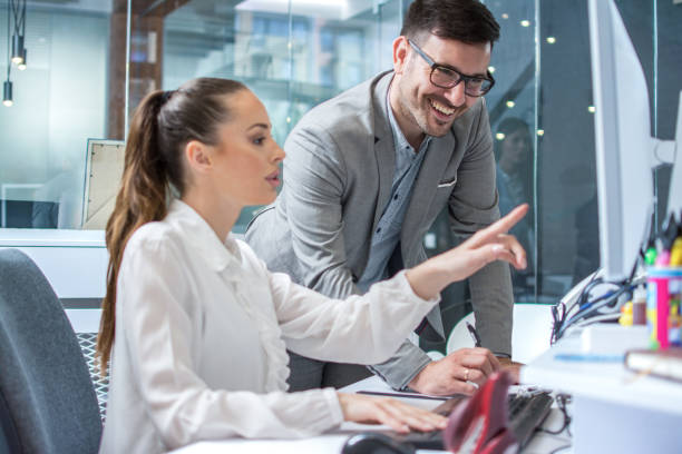 istock Handsome man taking notes to clipboard while his female employee pointing date on computer screen in corporate office. 2085603970