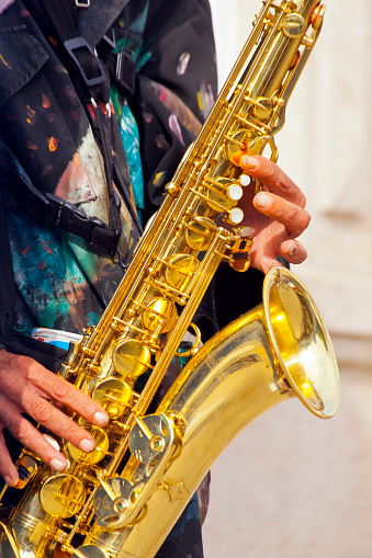 Close up of man playing saxophone in the street.