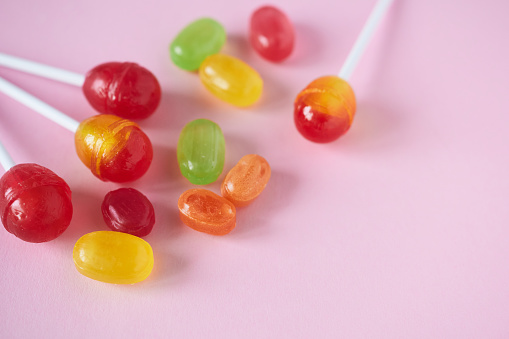 Colorful candies on pink background. Top view. Copy space.