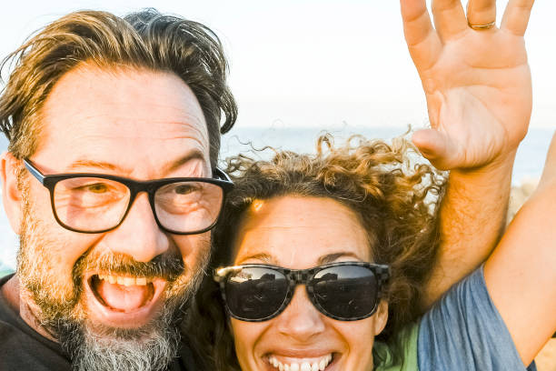 istock Couple on a roller coaster have fun with arms in the air amused and excited enjoying funny leisure activity together. Sunny afternoon holiday. Concept of free time and cheerfulness people happy 2085642448