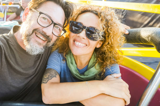 istock Happy smiling young couple at theme park smile enjoying rides at amusement park. Close-up of happy fifty year old couple at theme amusement park. travel, tourism, couple, people, vacation concept 2085643621