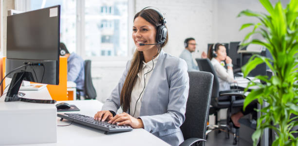 istock Beautiful young customer service representative wearing headset working on computer at cal center office. 2085660348