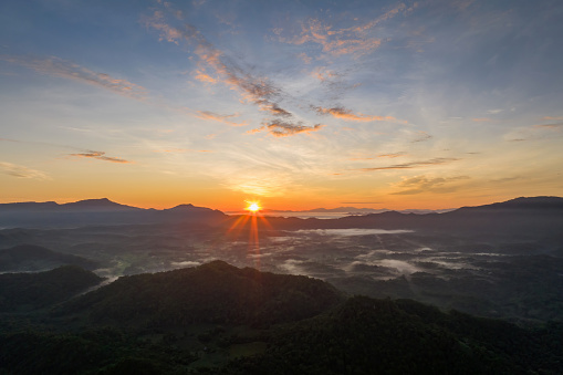Landscape view of dawn, golden light, sun rise, and mist flowing through the high mountain forest in Mae Moh, Lampang.