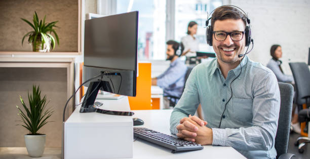 istock Portrait of friendly bearded customer support agent with headset in a call center. 2085677533