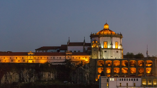 Illuminated Monastery of Serra do Pilar at evening twilight seen from Porto at the other side of the Douro River in Vila Nova de Gaia, Porto, Portugal