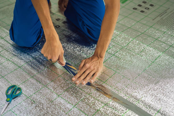 istock Master installs the overlapping thermal insulation in the room. Floor heating installation. Male hand holds reinforced tape. Repair in the apartment, floor insulation 2085702200