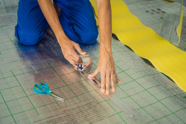 istock Master installs the overlapping thermal insulation in the room. Floor heating installation. Male hand holds reinforced tape. Repair in the apartment, floor insulation 2085702208