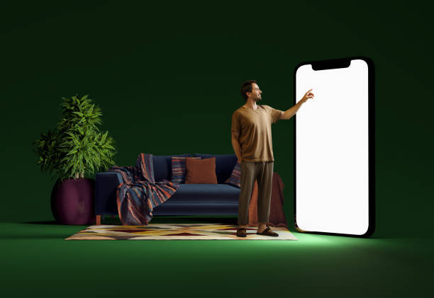 istock Smiling man in home wear standing in room and pointing at big mobile phone screen, using online services for shopping. 3D model of phone 2085704839