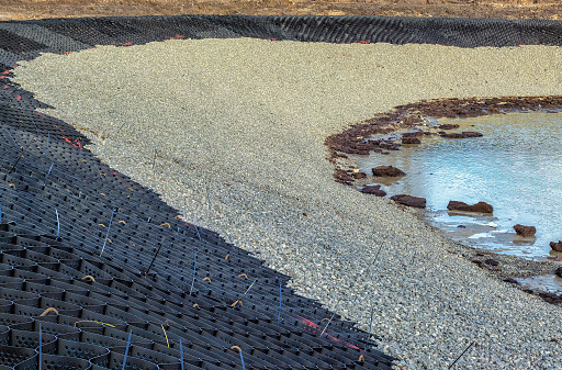 geostrips are attached to the slope of the pond and rubble is filled in to prevent rainwater from washing off the slope.