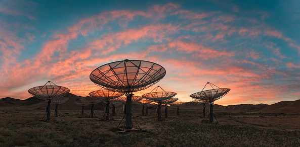 Radio antenna dishes of the Very Large Array radio telescope at  sunset