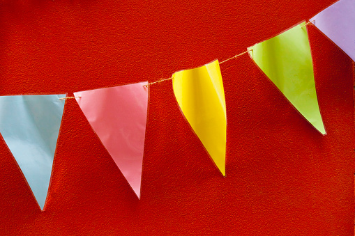 Multicolored feast decoration, bunting, red background. Traditional festival. Galicia, Spain.