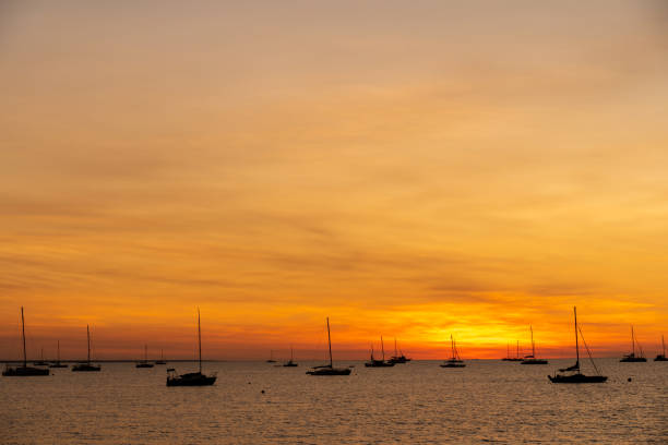 Sailing boats at Vesteys beach at sunset in Darwin, Australia.