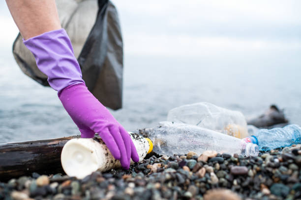 istock Man picking up plastic garbage on a sea shore. Plastic pollution and global ocean ecological and environment problems concept. 2085772460