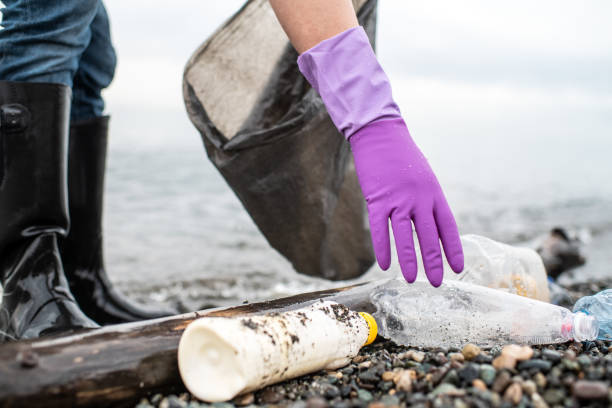 istock Man picking up plastic garbage on a sea shore. Plastic pollution and global ocean ecological and environment problems concept. 2085773486