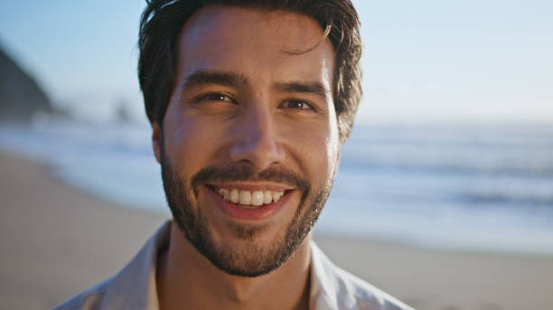 istock Closeup hispanic man smiling standing on sunny beach. Portrait happy bearded guy 2085784913