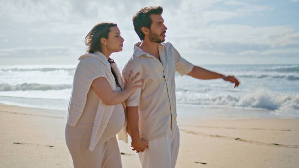 istock Relaxed future parents strolling picturesque ocean coast enjoying landscape. 2085812831