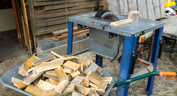 panorama Circular saw with cut firewood in the background