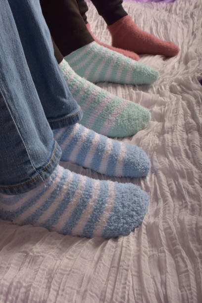 foot of three people wearing socks