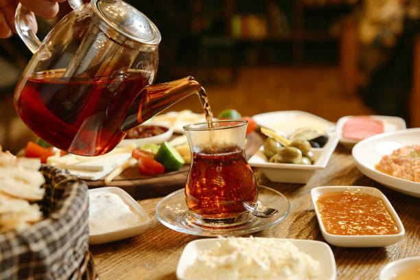 istock Person Pouring Tea Into Glass Cup 2085914731