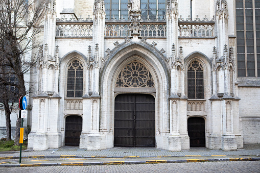 A large wide door made of boards, the entrance to the church, a wide staircase made of stone and a white wall photo