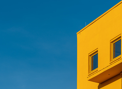 Germany, Berlin, January 29, 2024 - Yellow office building against clear sky, Berlin Neukölln