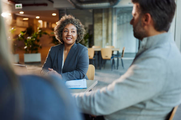 istock Happy insurance agent talking to her customers in the office. 2085945824