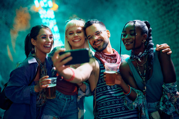 istock Happy festival goers having fun while taking selfie at night. 2085947436