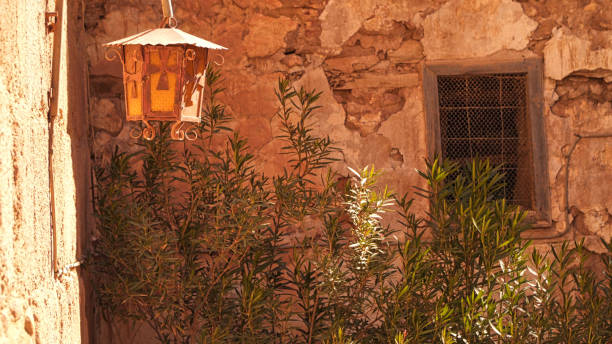 Vintage lantern hangs on a stone wall adorned with autumn leaves in the cotswolds, england
