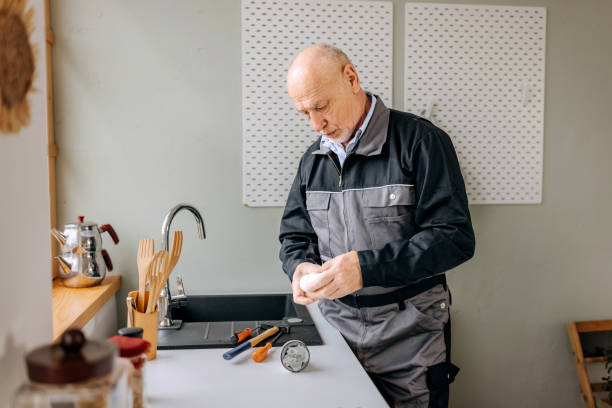 istock Senior plumber repairing kitchen sink 2085956630