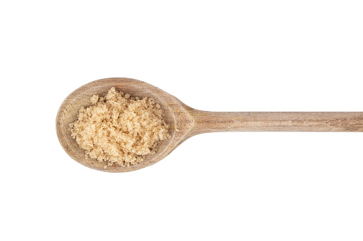 a small pile of raw sugar on a wooden spoon