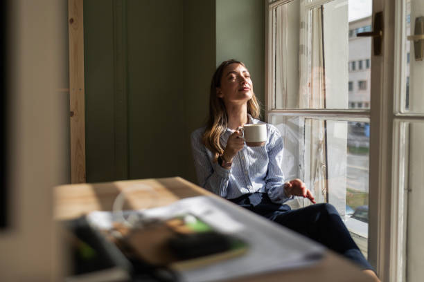 istock Businesswoman Taking a Coffee Break on Window Ledge 2085974195