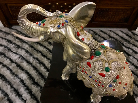 A traditional, miniature elephant tusker memento made in silver metal.