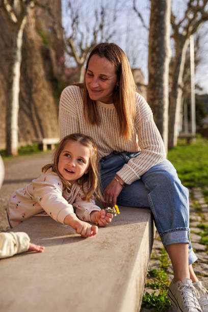 istock Mother and daughter on park bench 2086002379