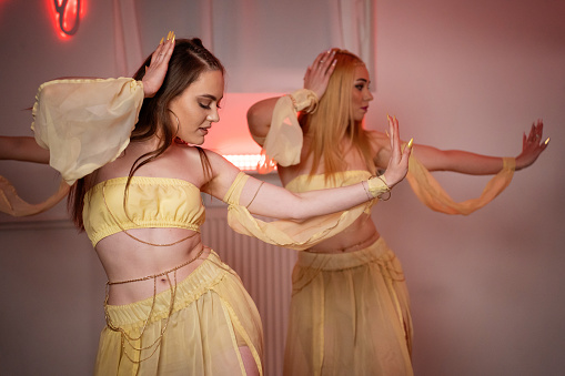 Young adult females practicing dance choreography at studio