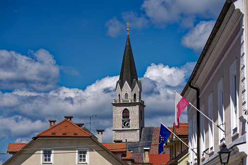 Old town of Slovenian City of Kranj with alley and colorful historic houses and a church tower of St. Kancijan’s Church on a sunny day. Photo taken August 10th, 2023, Kranj, Slovenia.