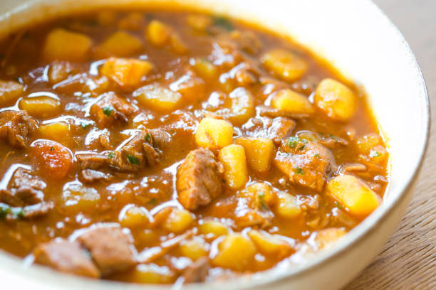 Traditional goulash soup with potatoes, carrots, beef on plate, ready to eat, close-up
