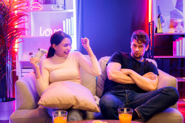 istock Smiling beautiful woman winner on video game beside man loser. Postulate. 2086057861