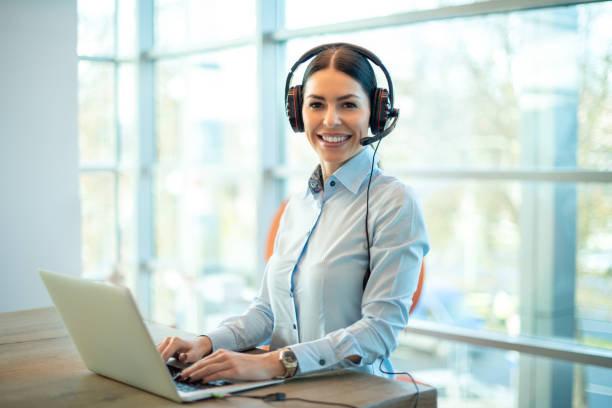 istock Beautiful call center worker holding hands on keyboard and looking at camera. 2086089959