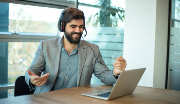 istock Friendly call center male operator with headset talking to a client during video call. 2086097940
