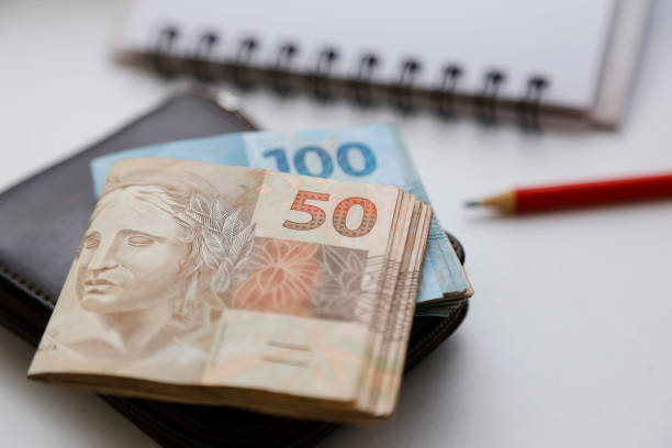 istock fifty reais notes and other notes on the table with wallet, pencil and notebook 2086100534