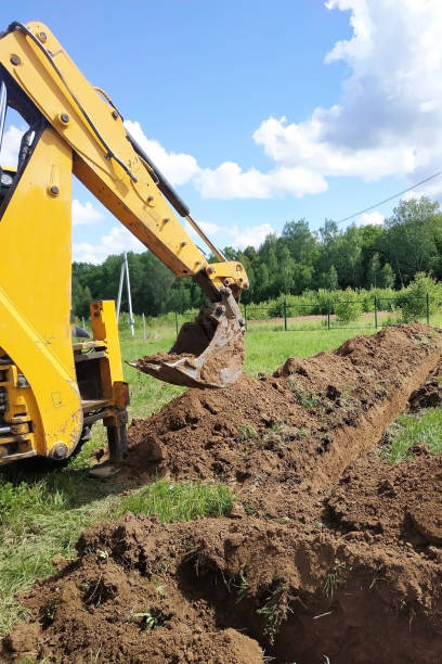 istock A yellow excavator digging a trench on the construction site, a close-up, against the sky. 2086120703